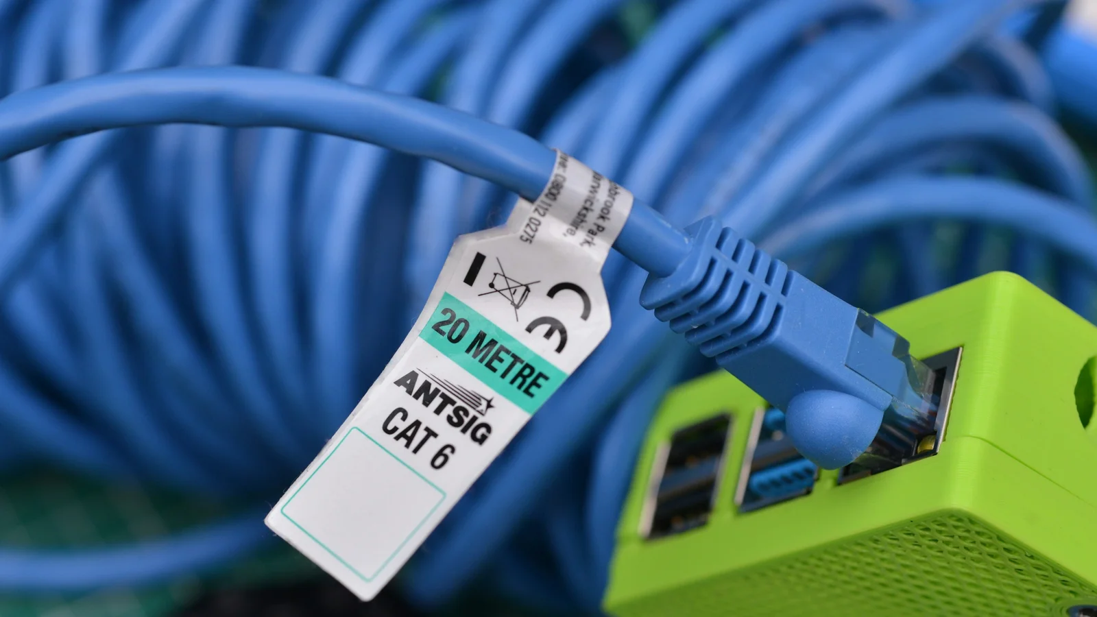 A blue Ethernet cable connected to a network port on a small computer.