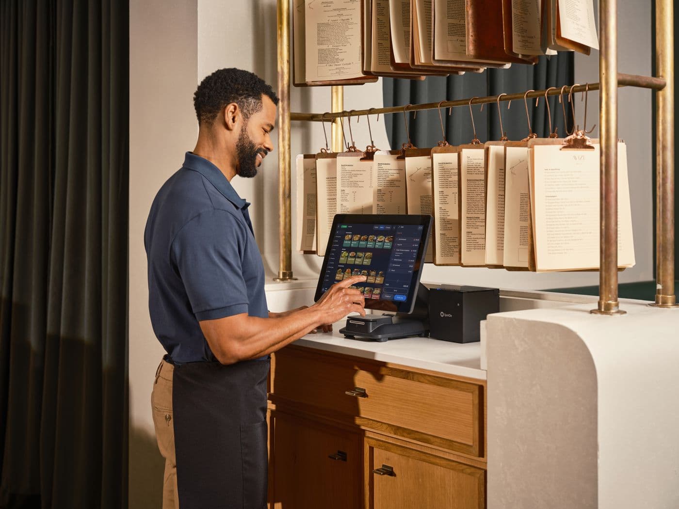Restaurant employee using a touchscreen POS at the counter